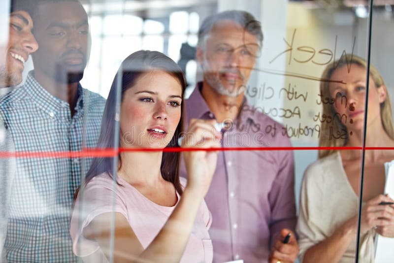 Ascultarea cu atenție a ideii sale de afaceri. un grup de colegi de afaceri care se gândesc împreună la un zid de sticlă. royalty free stock images