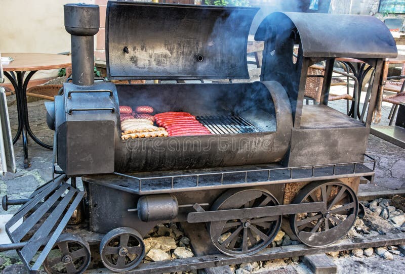Ase a la parilla la parrilla con la carne en forma de la locomotora de vapor vieja imagen de archivo libre de regalías Ase a la parilla la parrilla con la carne en forma de la locomotora de vapor vieja imagen de archivo libre de regalías