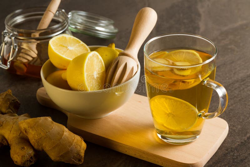 Asesinos naturales de la gripe - té caliente del limón con el jengibre y la miel foto de archivo Asesinos naturales de la gripe - té caliente del limón con el jengibre y la miel foto de archivo