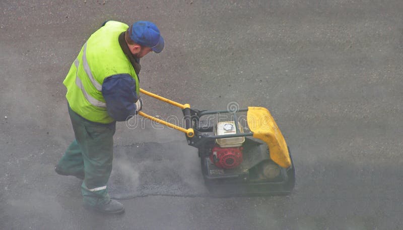 Road mender at work; hard work, power, blue-collar concept. Road mender at work; hard work, power, blue-collar concept