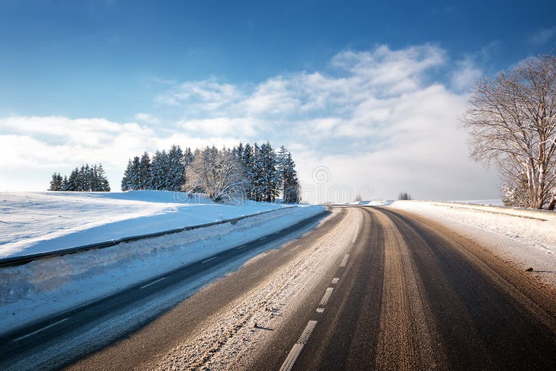 Asfaltväg i snöig vinter på härlig solig dag royaltyfri bild Asfaltväg i snöig vinter på härlig solig dag royaltyfri bild