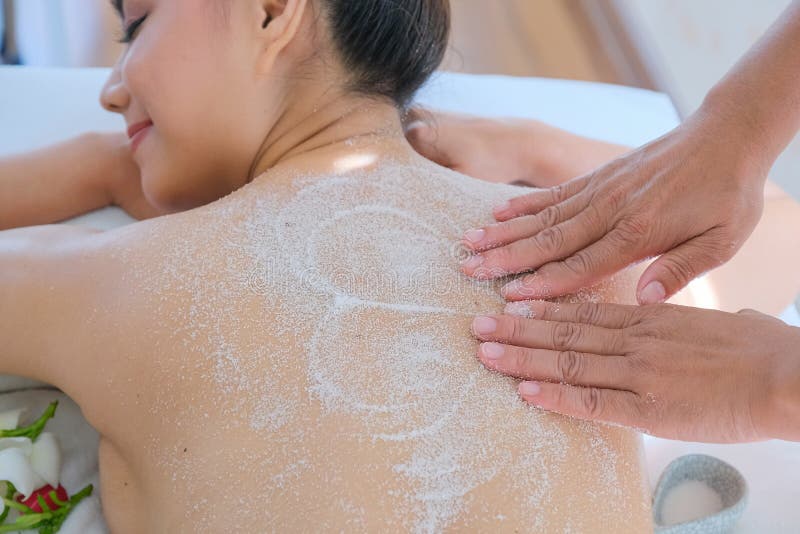 Asia beautiful woman enjoying a salt scrub massage at the health spa in Thailand stock photo Asia beautiful woman enjoying a salt scrub massage at the health spa in Thailand stock photo