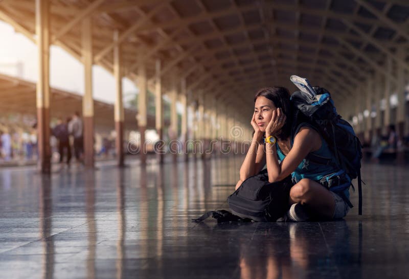 Asia woman with bag backpack and sitting bored wait a time for traveler trip at train station