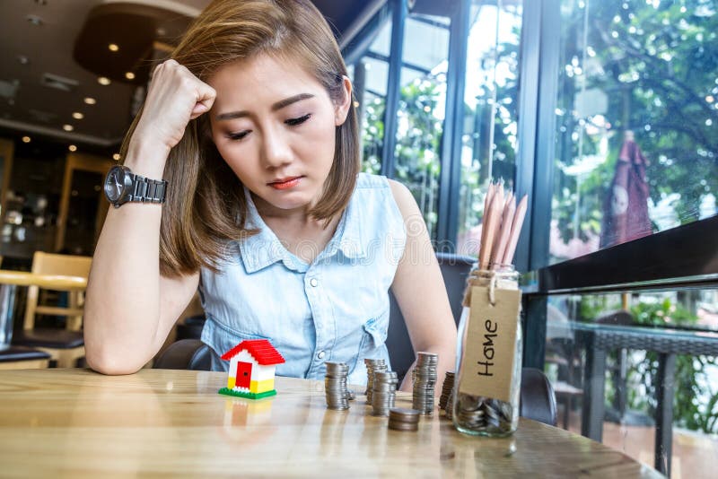 Asia woman with house model and money bottle royalty free stock photos Asia woman with house model and money bottle royalty free stock photos