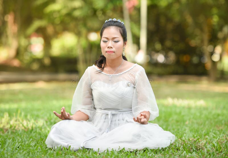Asia woman yoga Meditation on green grass stock images Asia woman yoga Meditation on green grass stock images