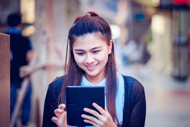 Asia women using tablet and cellphone in economic zones.