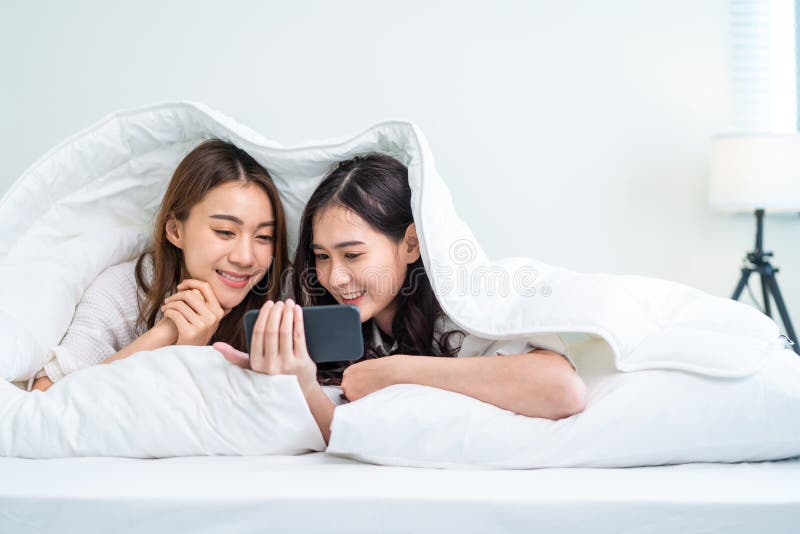 Asian Attractive Lesbian Couple Use Mobile Phone Watch Movie On Bed Beautiful Sibling In