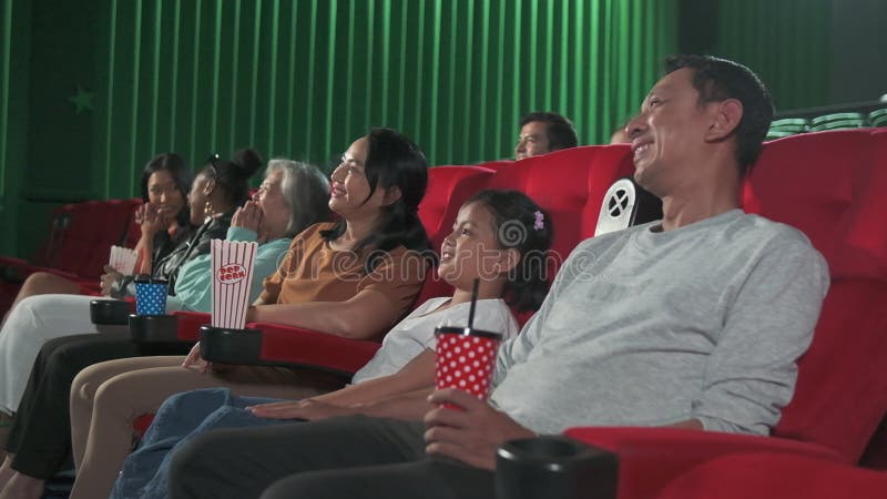 An Asian audience enjoys watching cinema together at movie theaters.