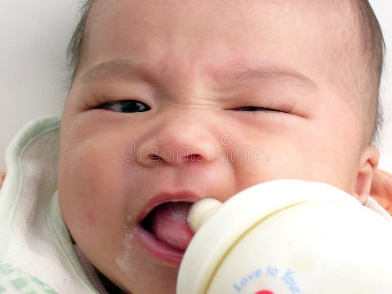 Asian baby milk feeding with one eye winking