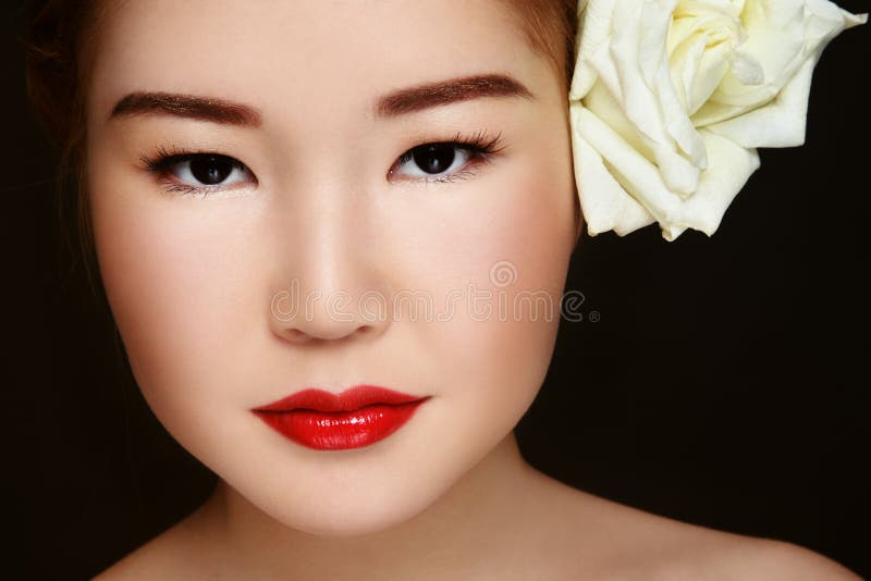 Close-up portrait of young beautiful asian girl with white rose in hair. Close-up portrait of young beautiful asian girl with white rose in hair