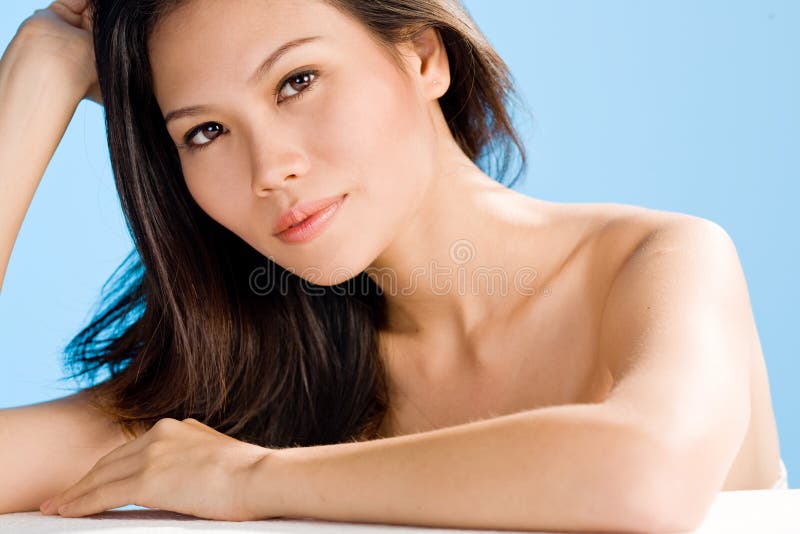 A beautiful asian woman's face with long curly hair. A beautiful asian woman's face with long curly hair