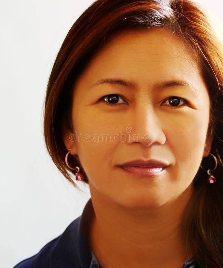 Portrait of an Asian beauty with chocolate brownish hair and dangling earrings. Portrait of an Asian beauty with chocolate brownish hair and dangling earrings.