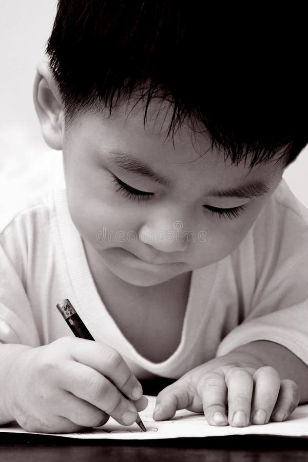 Asian boy drawing on paper