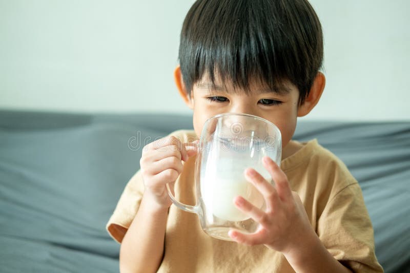 Asian boy is drinking a glass of milk royalty free stock photos