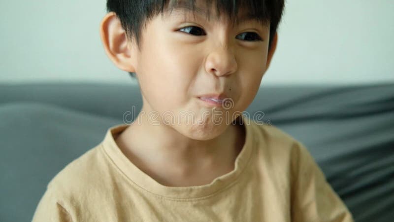 Asian boy drinking milk from a glass with a bright smile. stock video footage