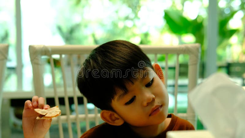 Asian boy eating processed food made from mushrooms stock video footage