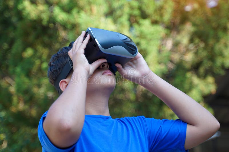 Asian boy enjoys exploring virtual worlds with Virtual Reality Headsets
