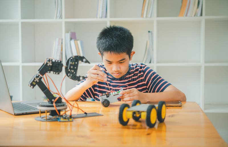 Asian Boy Learning and Studying the Work of Technology Robots