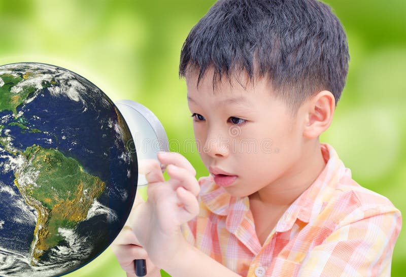 Asian boy looking at glowing globe by magnifying glass stock photography Asian boy looking at glowing globe by magnifying glass stock photography