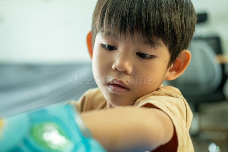 Asian boy reaching for a bag of candy stock images