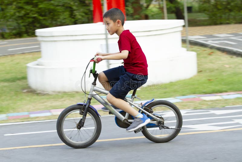 Asian boy riding bicycle in the park