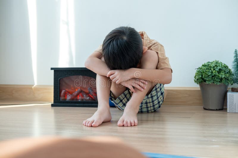 An Asian boy sits in his bedroom crying royalty free stock photo