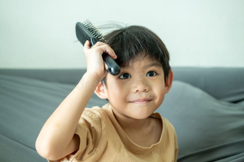 Asian boy using a comb to comb his hair stock photos