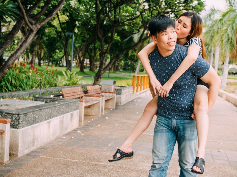 Asian Boyfriend Carrying His Smiling Girlfriend in Public Park Stock ...