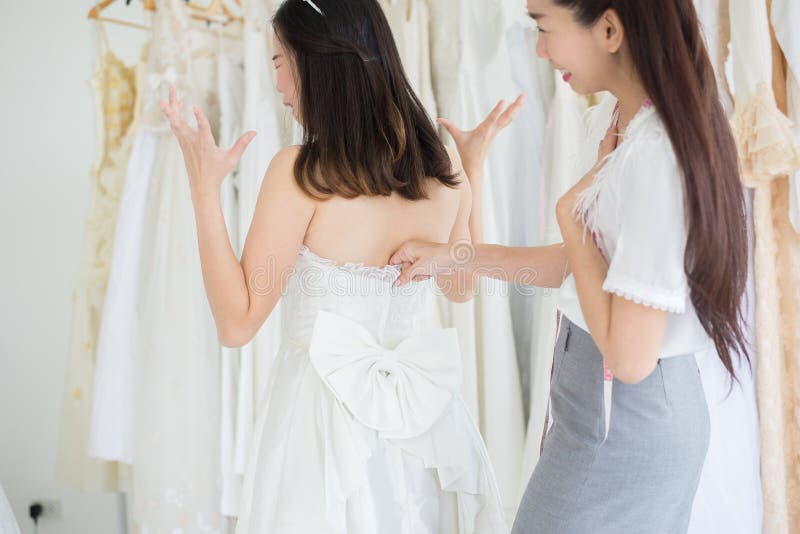 Asian Bride Trying On Wedding DressWoman Designer Makin