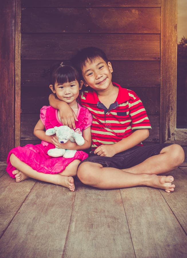 Asian brother put one s arm around sister s shoulder and smiling