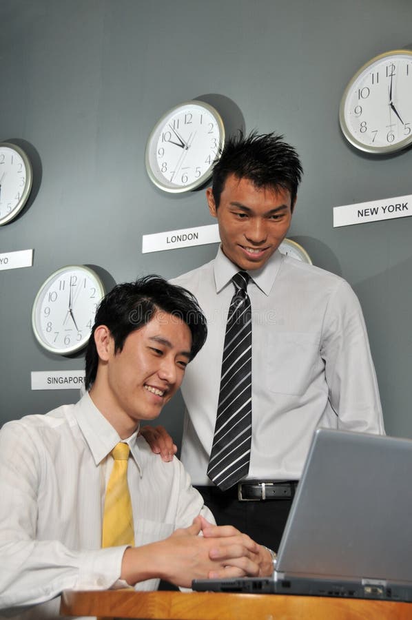 Asian Business executives in room full of clocks