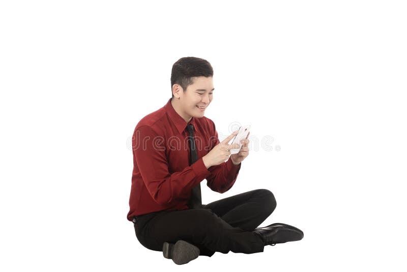 Asian business man texting with cellphone and sitting on the floor