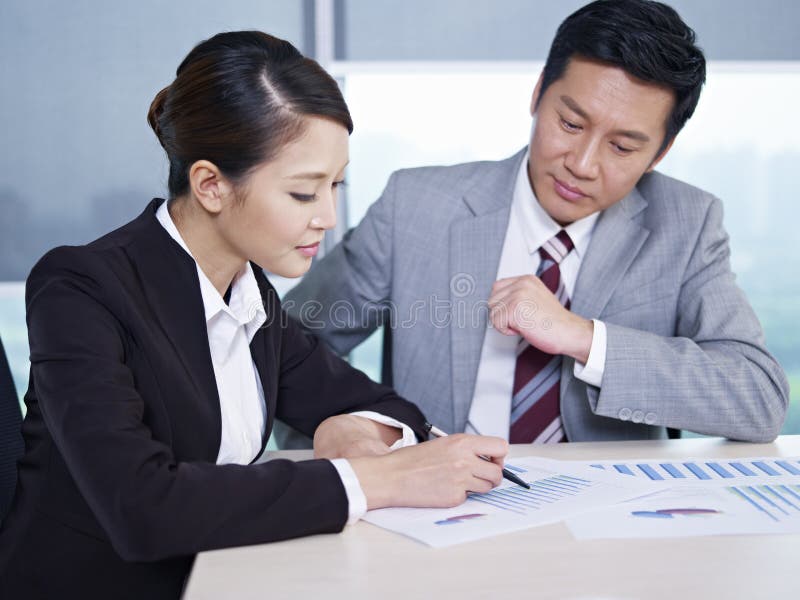 Asian business executives discussing business in office; focus on the woman. Japanese women work stock images, royalty-free photos and pictures