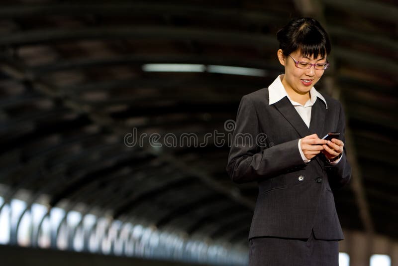 Asian business woman posing with mobile or hand phone, modern communication. Asian business woman posing with mobile or hand phone, modern communication