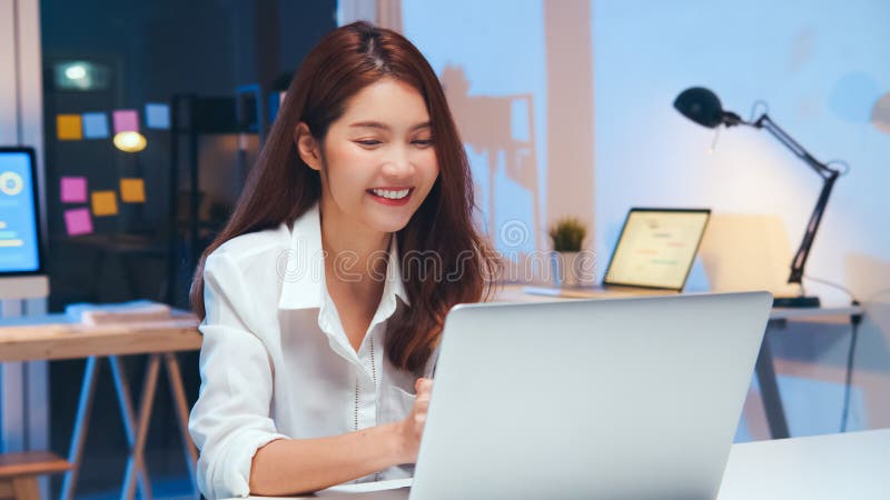 Asian business woman on video conference call, using laptop computer work late night. Remote meeting, work at home concept