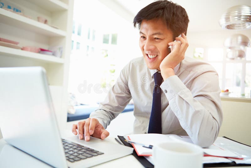 Asiatico, Uomo D'Affari Di Lavoro Da Casa Usando Il Telefono Cellulare E Computer Portatile Sorridente.