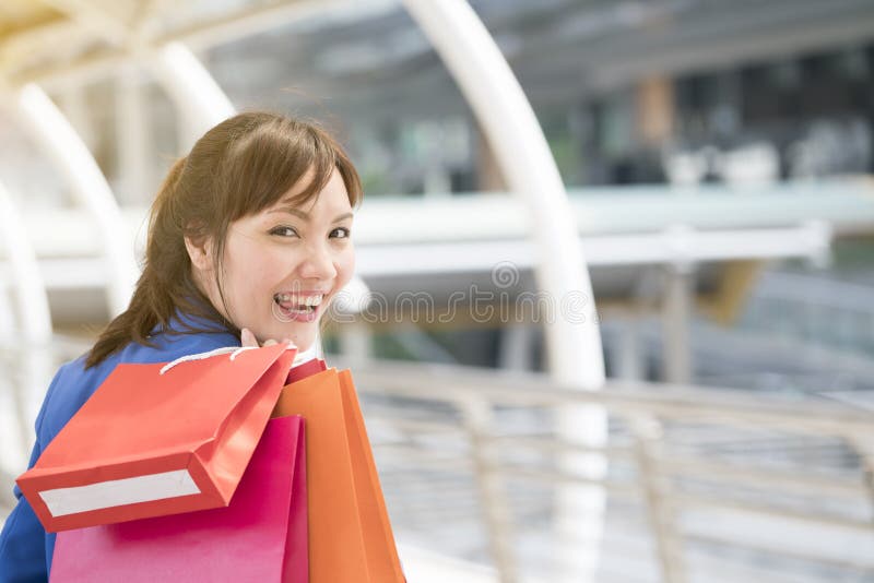 Asian businesswoman holding colorful paper shopping bags on hand