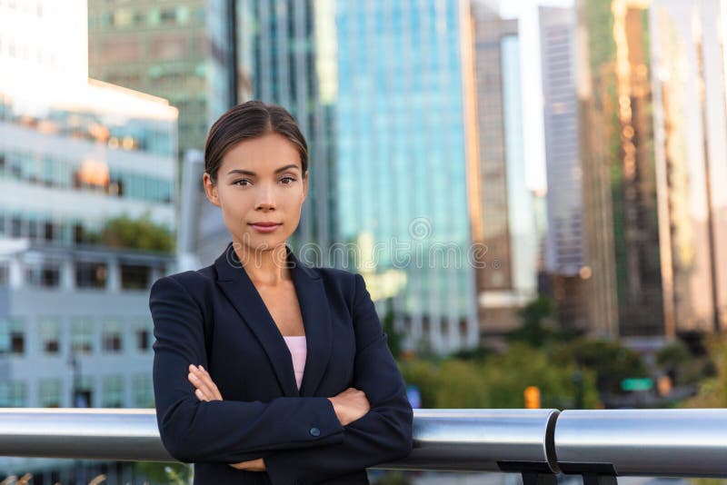 Asian businesswoman. Serious business woman portrait. Chinese professional in black suit in city background, downtown