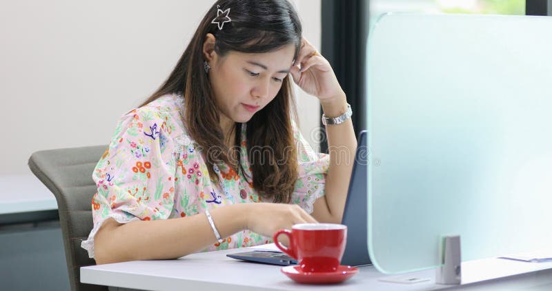 Asian businesswoman serious about the work and using notebook for business partners discussing documents and ideas at meeting