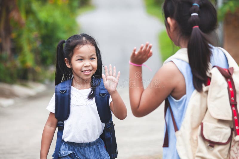 Asian Child Girl with School Bag and Her Elder Sister Making Hi Five ...