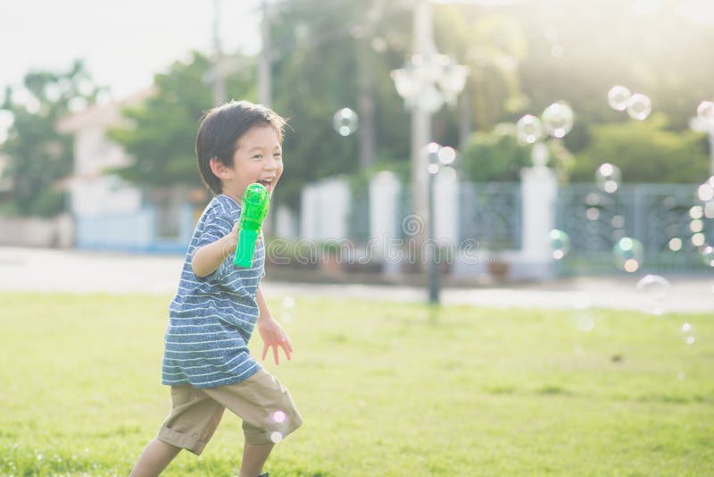 Asian Child Shooting Bubbles from Bubble Gun Stock Photo Image of