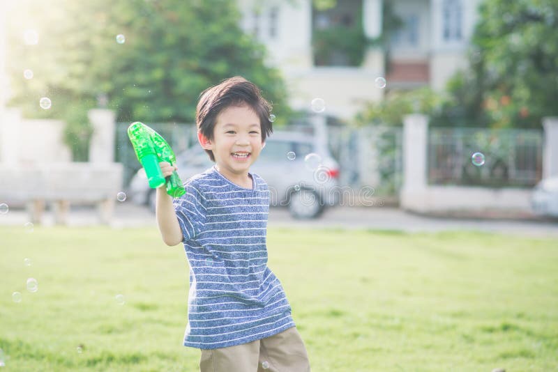 Asian Child Shooting Bubbles from Bubble Gun Stock Photo Image of