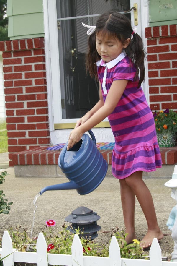 Asian Child Watering Flowers