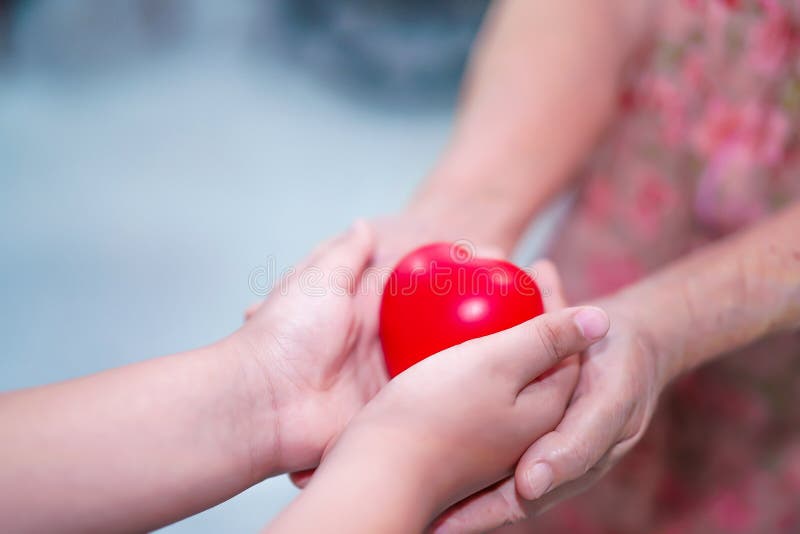 Asian children kid hold touch and give red heart strong health to old mother lady hands with love, happy, care. royalty free stock photos Asian children kid hold touch and give red heart strong health to old mother lady hands with love, happy, care. royalty free stock photos