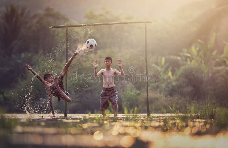 Asian children play soccer in the river