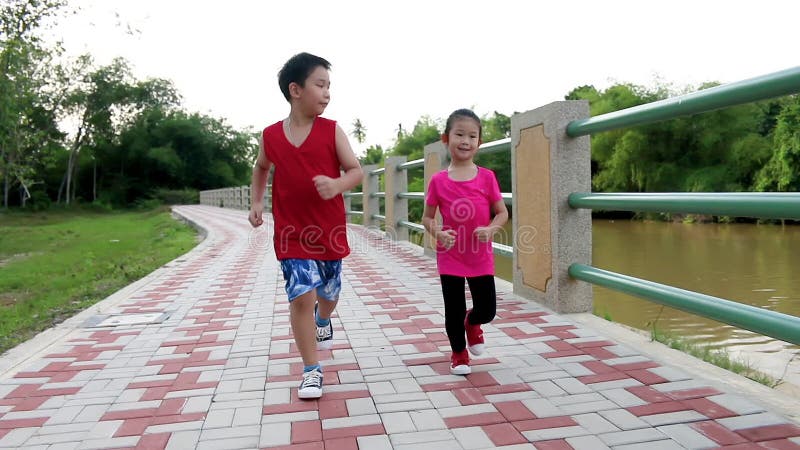 Asian children runner in sportswear jogging in public park. Healthy Lifestyle.