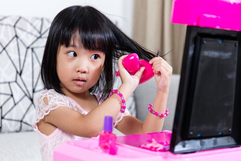 Asian Chinese Liitle Girl Playing With Make-Up Toys stock photography Asian Chinese Liitle Girl Playing With Make-Up Toys stock photography