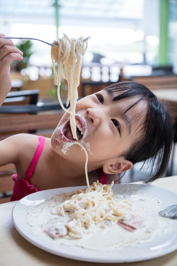 Asian Chinese little girl eating spaghetti