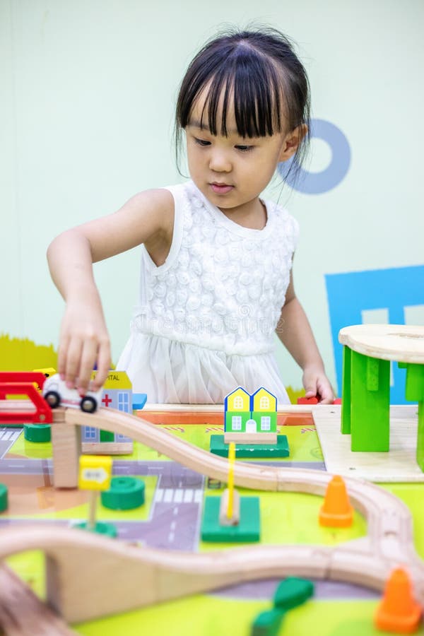 Asian Chinese little girl playing wooden toy train