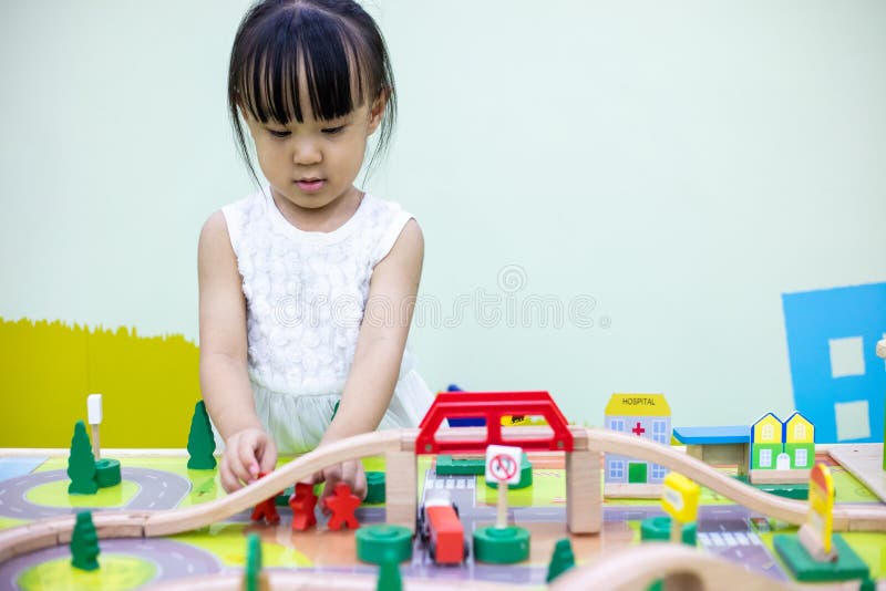 Asian Chinese little girl playing wooden toy train